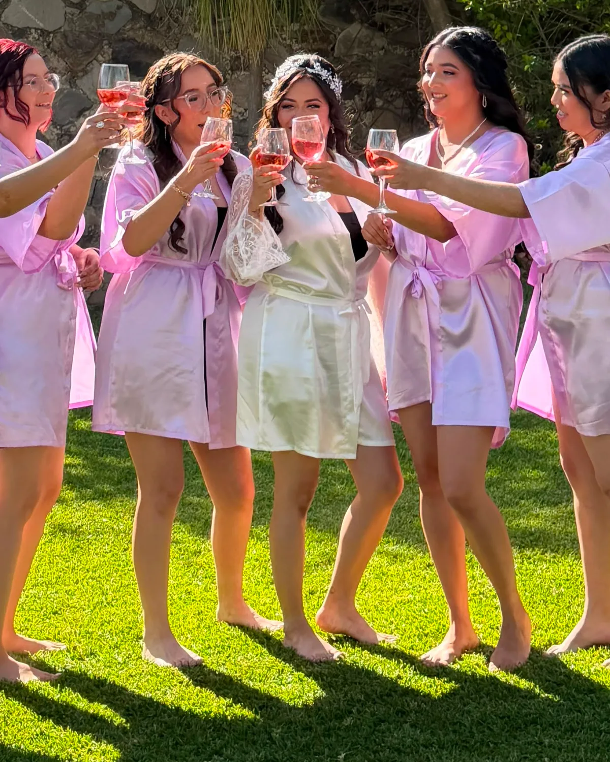 Novia brindando con sus damas, todas maquilladas y peinadas