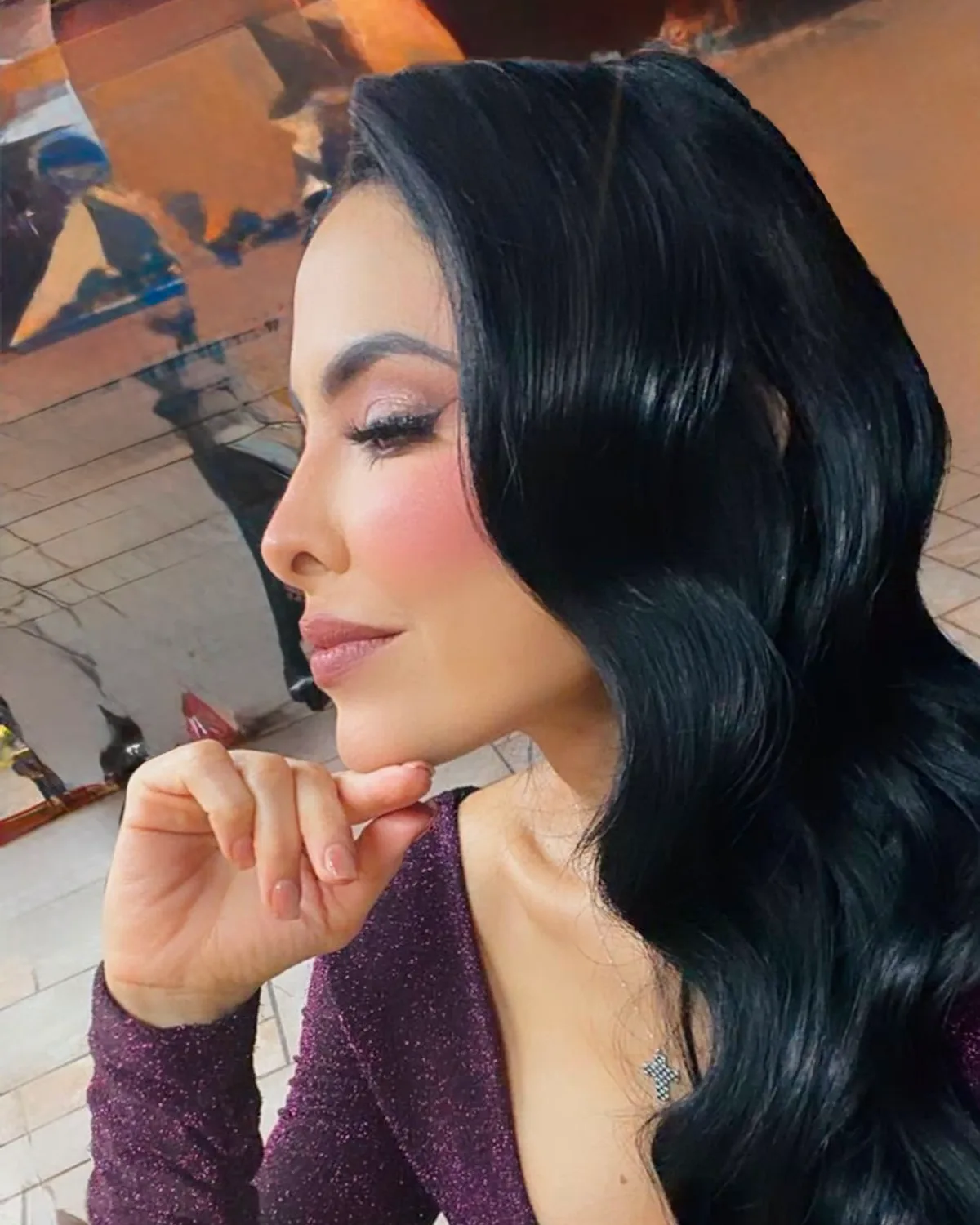 Ondas Hollywood pulidas en cabello negro con maquillaje glam