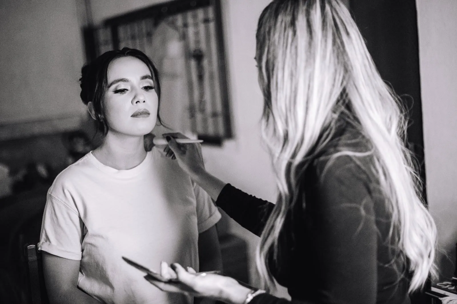 Janette Fonseca maquillando a una clienta con playera casual, fotografía documental en blanco y negro
