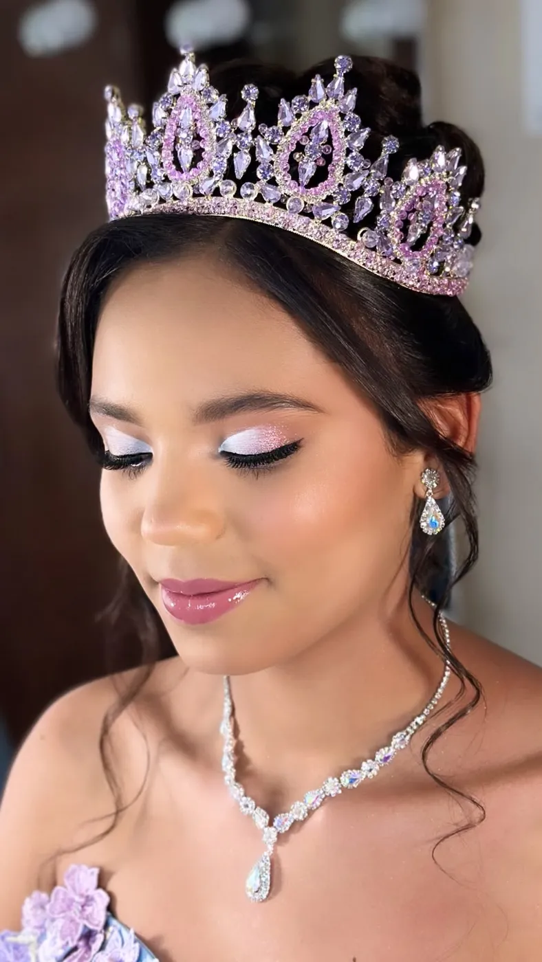 Quinceañera con corona lila, glitter rosa y sonrisa suave